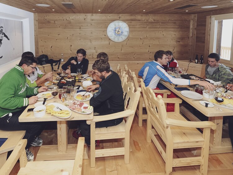 Eine Gruppe geniesst ein gemeinsames Raclette im Zügenhüttli Klosters. | © Davos Klosters Mountains