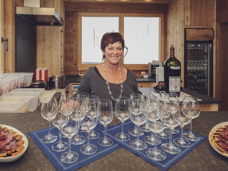 Kellnerin steht mit kleinem Willkommens Apéro aus diversen lokalen Spezialitäten für die Gäste bereit. | © Davos Klosters Mountains