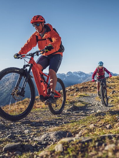 Ein Mann und eine Frau fahren mit dem E-Bike auf einem Singletrail in Davos Klosters. | © Davos Klosters Mountains