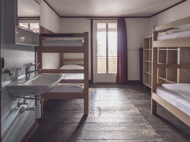 Mehrbettzimmer mit Stockbetten inkl. Bettwäsche,  Waschbecken und Kleiderablagen | © Davos Klosters Mountains 